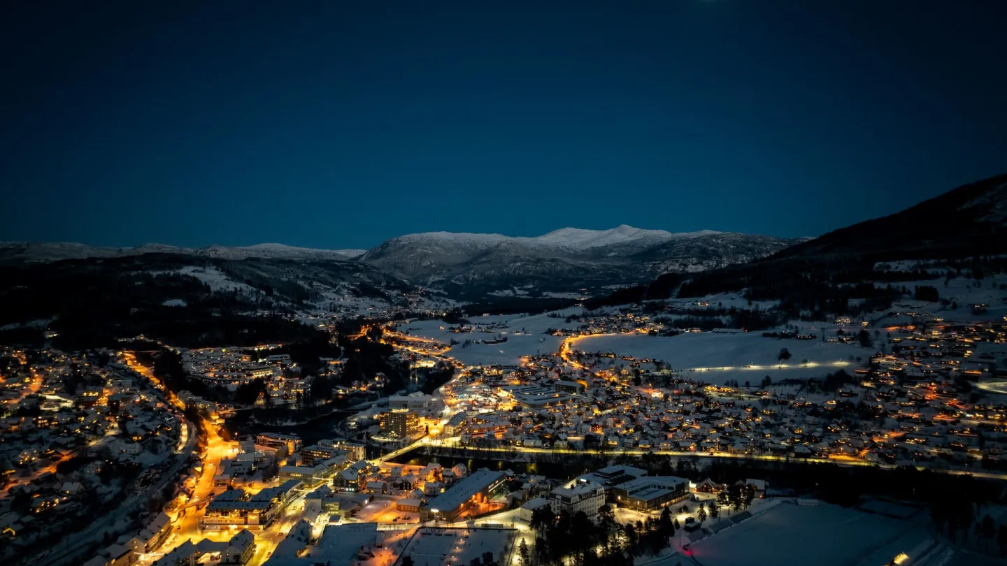 Dronefoto av Voss sentrum ein vinterkveld, sentrum lyser opp